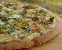 Une pizza végétarienne avec de la crème fraîche, de la courgette, de la mozzarella et des dés de pommes de terre.