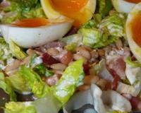 Une salade automnale avec des lardons, des oeufs mollets et une vinaigrette chaude à la fourme d'Ambert.