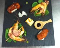 Les crevettes avec du lard puis cuite dans du beurre. Le riz collant et en forme de quenelles puis par dessus il y a une tranche de saumon fumé.