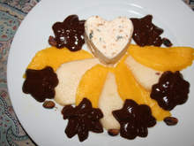 Nougat glacé, poire, mangue arrosés de chocolatet pistaches grillées