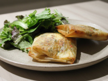 Brick à l'œuf avec oignons, fromage et herbes fraîches