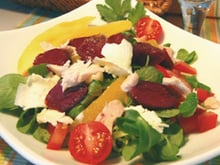 Salade de Gésiers de Canard maigre confits, vinaigrette tiède aux agrumes et pignons de pins torréfiés