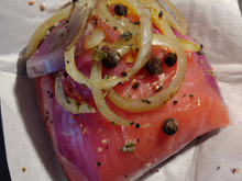 Papillote de saumon sur lit de tapenade et oignon rouge