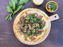 Agneau grillé au cumin, sauce à la menthe et persil plat, pain plat et houmous