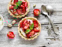 Tartelette aux fraises, crème à la pistache accompagnée d'une sucette de fraises glacée aux framboises entières