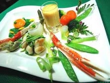 Légumes primeurs, huile de carapaces, langoustine royale, joues de raies caramélisées et jaune doux en écume de rouille