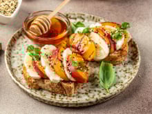 Fraîches et gourmandes, Cyril Lignac partage sa recette de tartines croustillantes à la burrata et aux pêches rôties !