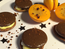 Macarons au chocolat à l'orange confite accompagnés de sa mousse chocolat blanc à la pistache et aux poires.