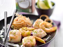 Brochettes de Saint-Jacques et gambas marinées au lait de coco et citron vert, vermicelles sautées au piment