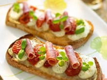 Bruschetta tomates confites, jambon italien, mozzarella et marmelade d'oignons