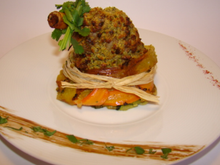 Souris d'agneau en croûte de pistaches vertes, sur un nid croustillant de légumes épicés et parfumés à la coriandre