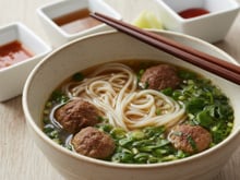Pho vietnamien : bouillon de bœuf, nouilles de riz, herbes fraîches et boulettes de bœuf
