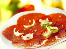 Carpaccio de bœuf aux fruits secs torréfiés et huile d'olive aux aromates, salade de roquette vinaigrette aux cidres