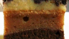 Bouchées totalement décadentes : brownie moelleux au chocolat noir surmonté d'une pâte cream cheese-cacahuètes, glaçage chocolat blanc, sur-glaçage chocolat noir & noisettes