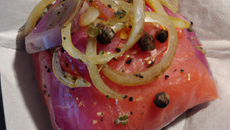 Papillote de saumon sur lit de tapenade et oignon rouge
