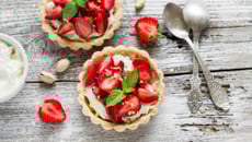 Tartelette aux fraises, crème à la pistache accompagnée d'une sucette de fraises glacée aux framboises entières