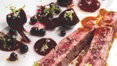 Entrecôte de bœuf saignante aux betteraves acidulées, baies de cassis, oignon rouge et tuile au poivre long