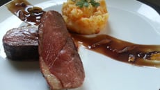 Magret de canard poêlé et son écrasé de pommes de terre carotte aux filaments d'abricots secs.