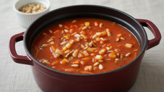 Potage aux tomates épicé au curry, dés de pommes et pignons de pin