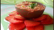 Mousse de fraise dans sa coque de chocolat au lait sur carpaccio de fraise au sirop de basilic