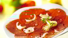 Carpaccio de bœuf aux fruits secs torréfiés et huile d'olive aux aromates, salade de roquette vinaigrette aux cidres