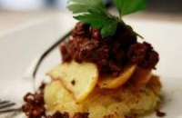 Lit de pommes de terre, poires confites et confit de canard