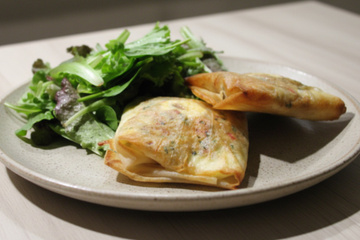 Brick à l'œuf avec oignons, fromage et herbes fraîches