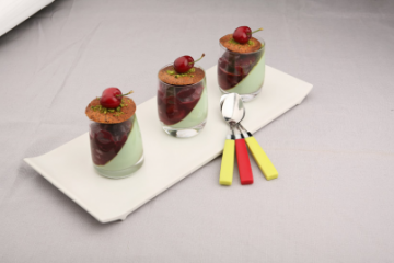 Panna cotta pistache, poêlée de cerises à l'hibiscus, tuile citron pavot