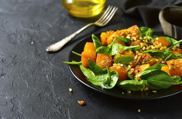 Salade de courge butternut rôtie et pousses d'épinards. Adobestock
