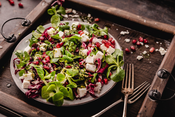Salade de mâche, endive, feta et graines de grenade. Adobestock
