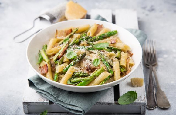 Penne aux asperges, bacon et parmesan. Adobestock
