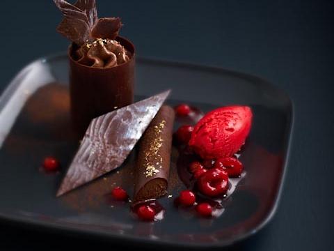 Dessert chocolaté avec sa compote de fruits rouges et son sorbet aux framboises