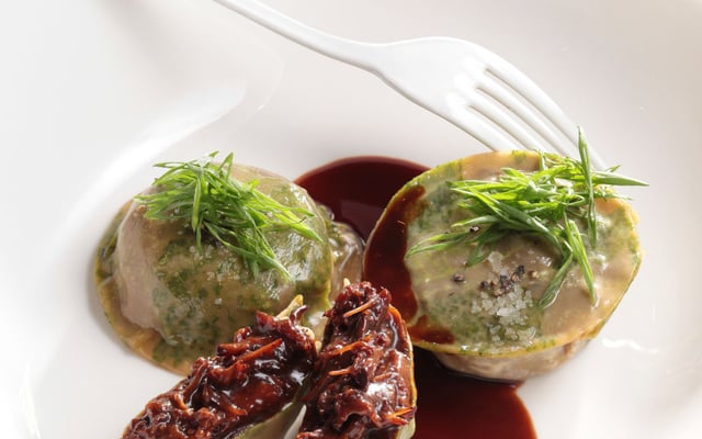Grosse raviole en imprimé d’herbes farcie d’efloché de bœuf dans la poire et foie gras, jus de braisage parfumé aux agrumes