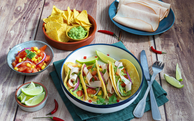 Tacos aux tranches de blanc de poulet, guacamole, tomates et maïs