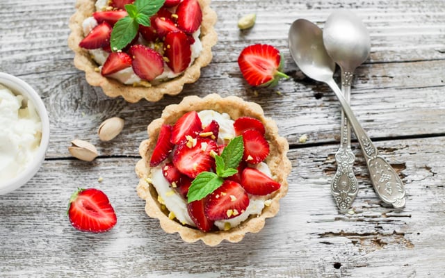 Tartelette aux fraises, crème à la pistache accompagnée d'une sucette de fraises glacée aux framboises entières