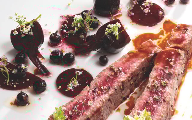 Entrecôte de bœuf saignante aux betteraves acidulées, baies de cassis, oignon rouge et tuile au poivre long