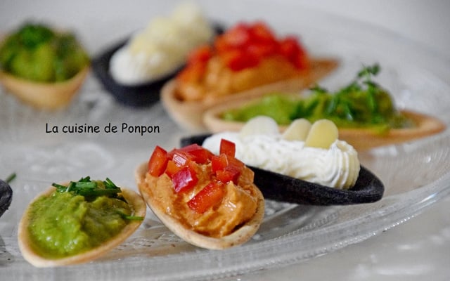Apéritif de fines coquilles garnies de crème d'avocat, crème de tomates et fines herbes