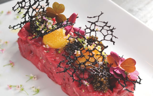 Pièce de bœuf taillée au couteau, condiments, caviar Schrenki, jaune cristalline et tuile au Sarrasin