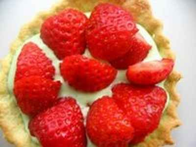 Tartelette aux fraises, crème à la pistache accompagnée d'une sucette de fraises glacée aux framboises entières
