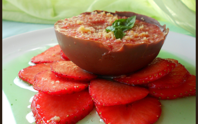 Mousse de fraise dans sa coque de chocolat au lait sur carpaccio de fraise au sirop de basilic
