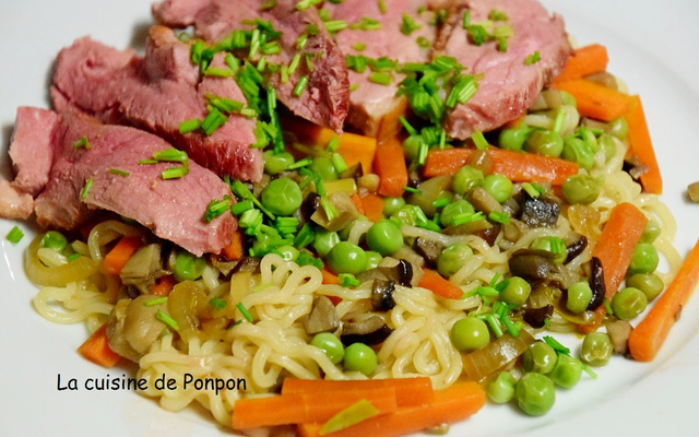 Filet de canard sur un lit de nouilles sautées et ses petits légumes
