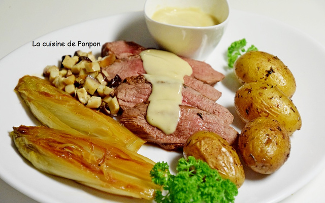 Magret de canard garni de sauce au foie gras, pommes de terre, chicons et champignons
