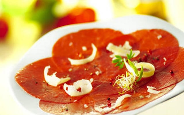 Carpaccio de bœuf aux fruits secs torréfiés et huile d'olive aux aromates, salade de roquette vinaigrette aux cidres