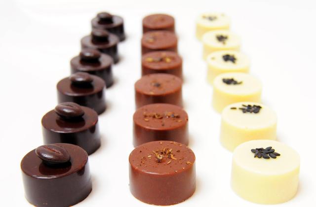 Assortiments de bonbons en chocolat épicés noir, blanc, lait - Photo par Pâtisserie et Gourmandise