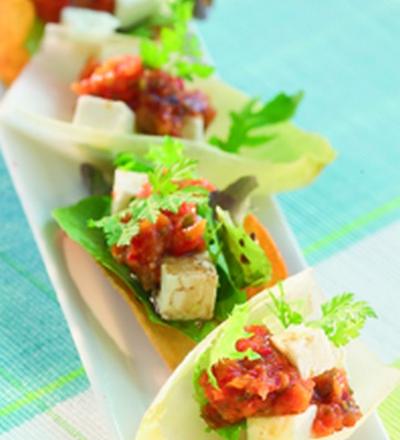 Feta et concassé de poivrons rouges sur feuilles d'endives