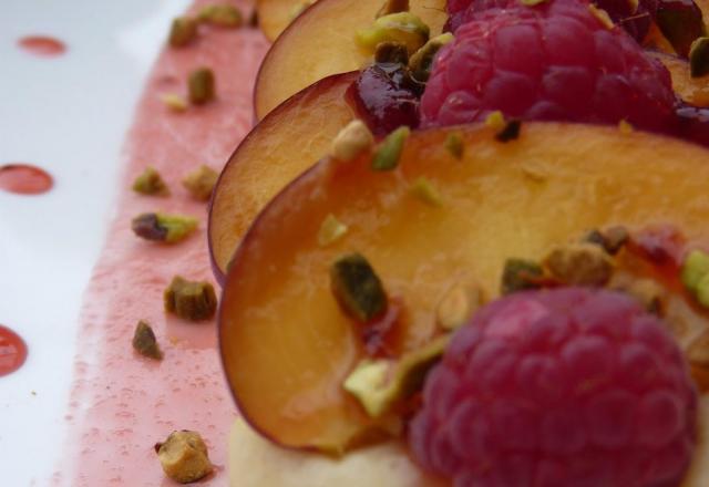 Tartines pêches-framboises parsemées de pistaches et de miel sur de la crème aux amandes