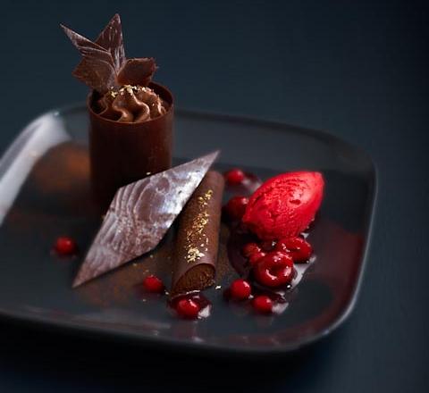 Dessert chocolaté avec sa compote de fruits rouges et son sorbet aux framboises