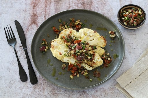 Et si vous testiez les tranches de chou-fleur rôti ? Une recette originale aux olives et tomates séchées