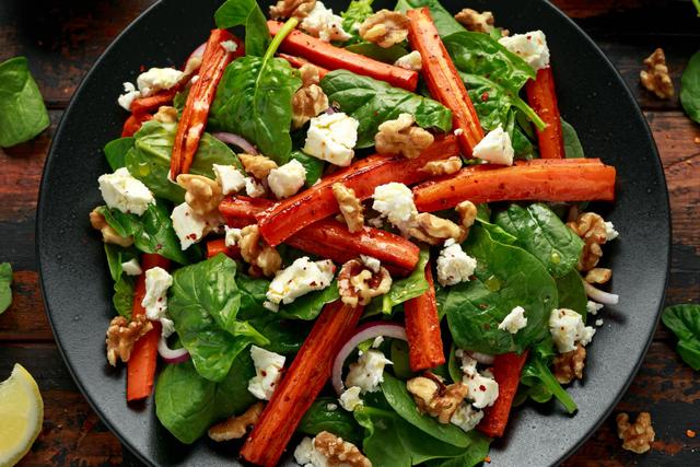 Salade de carottes rôties, pousses d'épinards, feta et noix. Adobestock