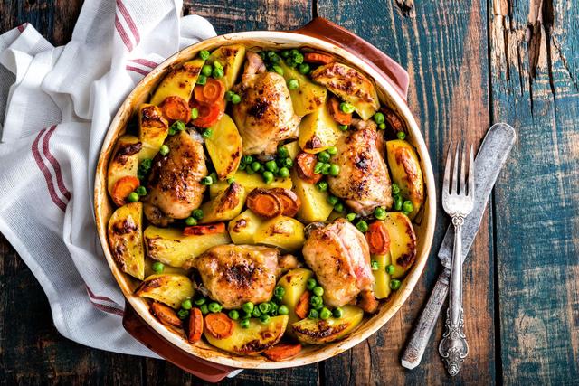 Poulet aux pommes de terre et carottes rôties et petits pois. Adobestock
